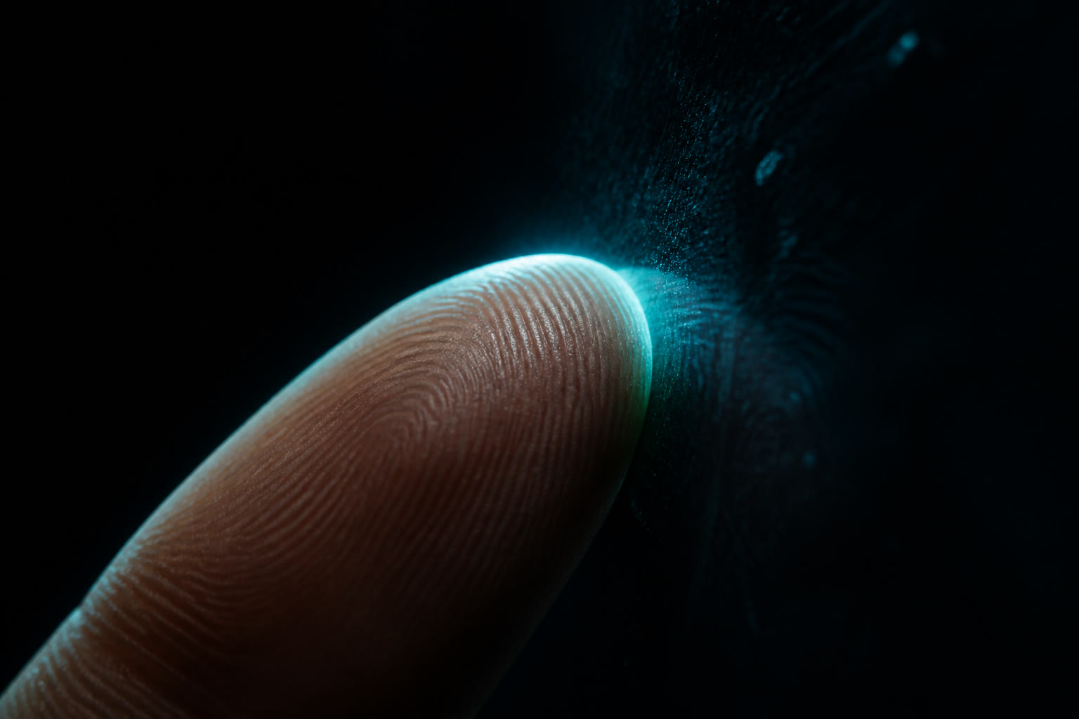 An extreme close-up of a single fingertip pressed against dark glass, ridge detail picked out by a cool rim light against near black.